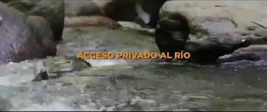 Agua del río corriendo entre piedras, con el rótulo original “Acceso privado al río”.