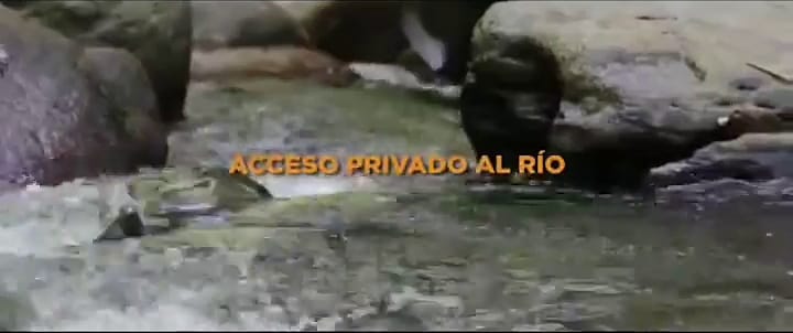 Agua del río corriendo entre piedras, con el rótulo original “Acceso privado al río”.