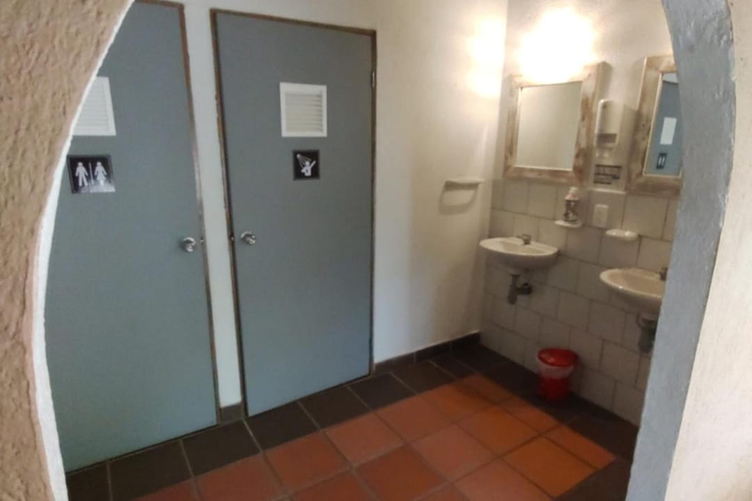 Entrada en arco a la zona de baños, con dos puertas y lavamanos.