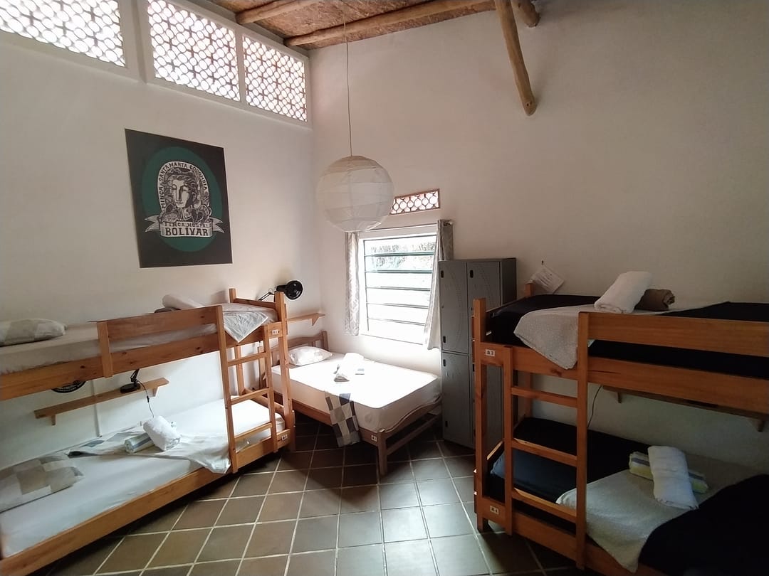 Dormitorio de seis de Casa Maracuyá: camarotes de madera, techo de madera y ventanas con calado.
