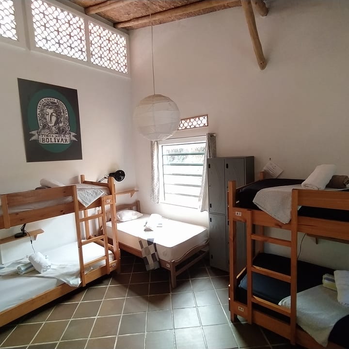 Dormitorio de seis de Casa Maracuyá: camarotes de madera, techo de madera y ventanas con calado.