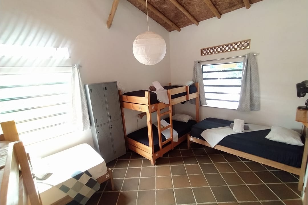Otro ángulo del dormitorio: camarote, cama sencilla y lámpara de papel.