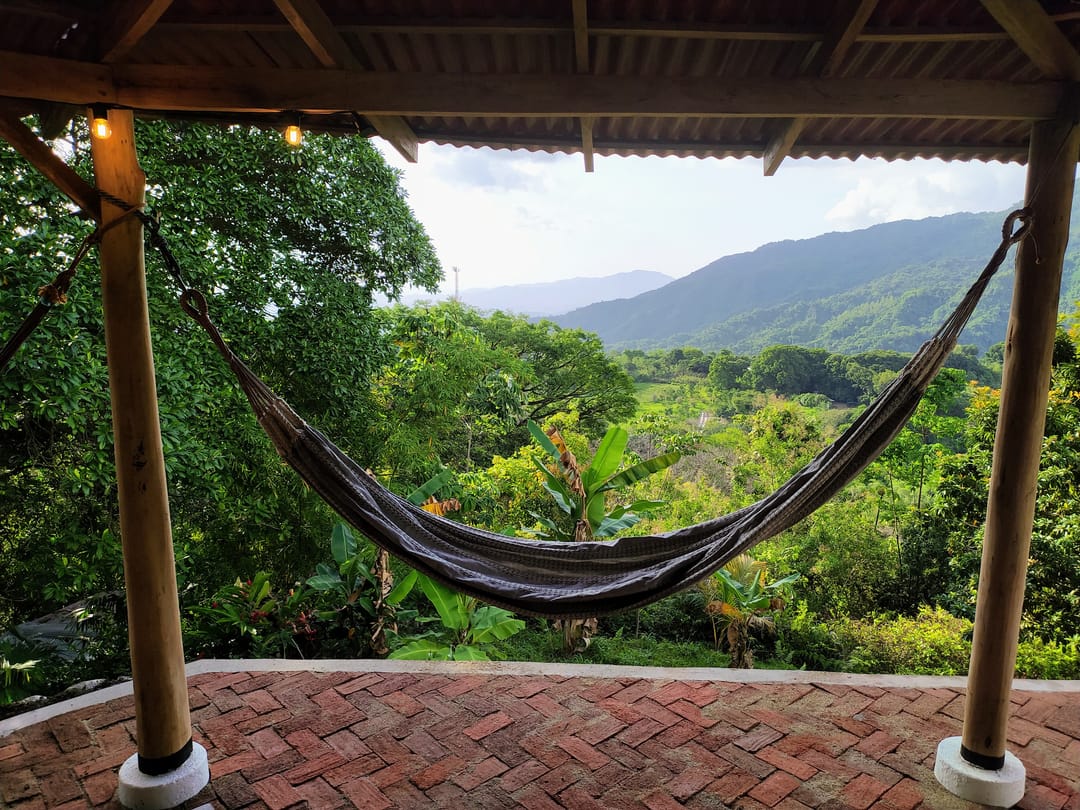 Una hamaca colgada en la terraza enmarca el valle y las montañas de la Sierra.