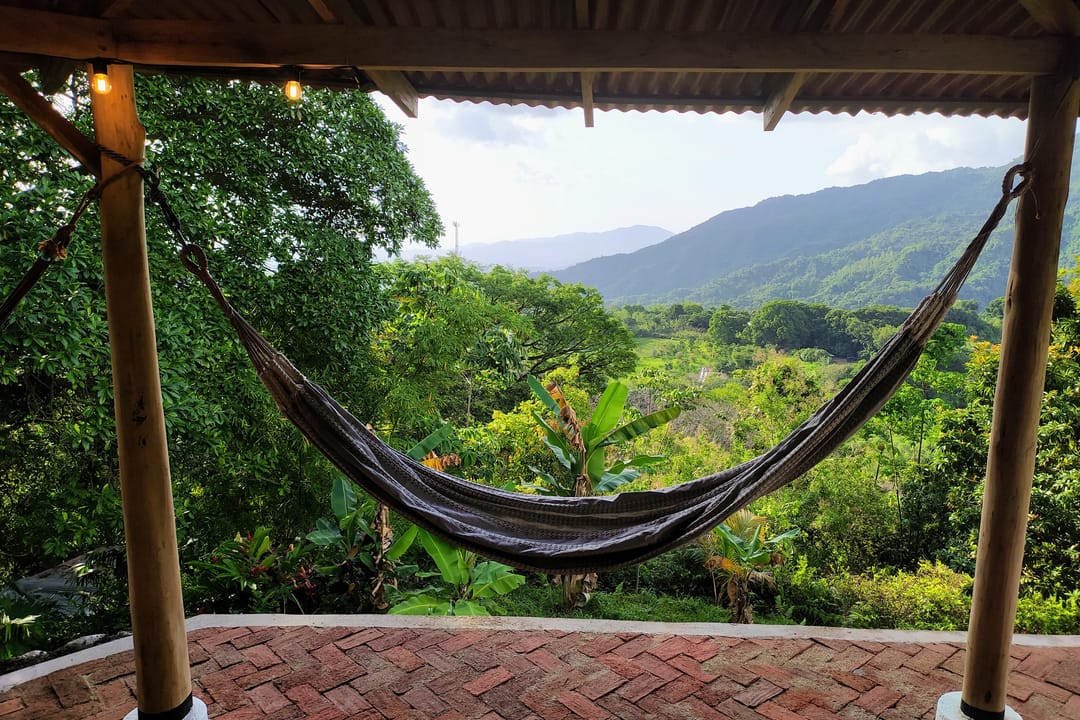 Una hamaca colgada en la terraza enmarca el valle y las montañas de la Sierra.