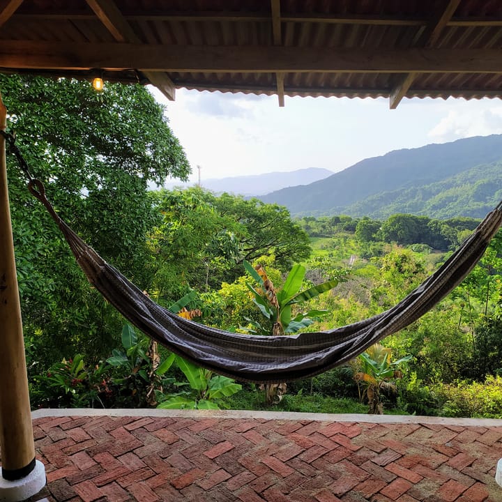 Una hamaca colgada en la terraza enmarca el valle y las montañas de la Sierra.