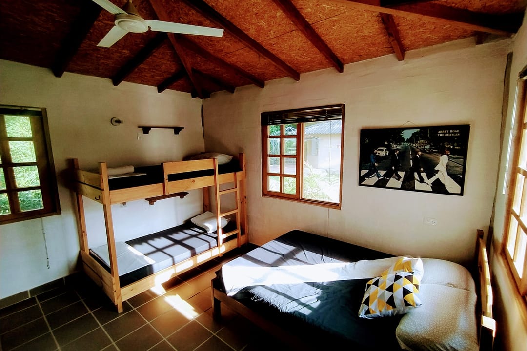 Otro ángulo del dormitorio: camarote, cama sencilla con cojines y un cuadro en la pared.