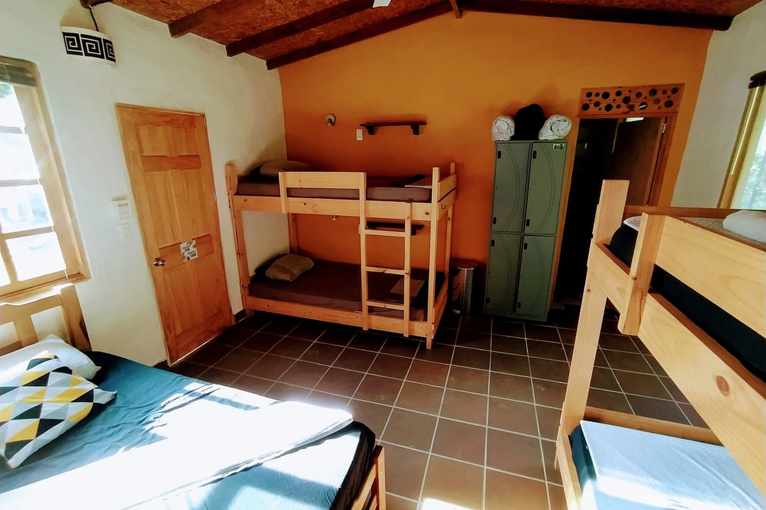 El dormitorio con camarote, lockers metálicos y una puerta de madera.